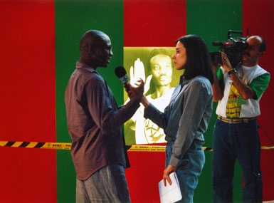 
	O artista Oladélé Ajiboyé Bamgboyé sendo entrevistado ao lado de sua obra An Exit Perhaps
